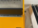 a yellow machine that is sitting next to a box
