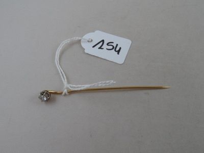 a small white tag with a gold stick attached to it