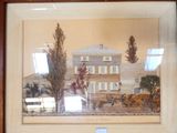 painting of a house in a frame on a wall in a room