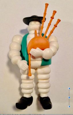 une figurine représentant un homme tenant une cornemuse dans ses mains