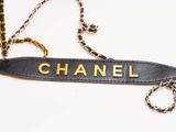 a black and gold chanel bag on a chain