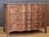 an antique chest of drawers on a wooden floor against a gray wall