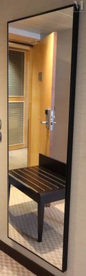 un miroir accroché au mur d'une salle de bains équipée d'un banc