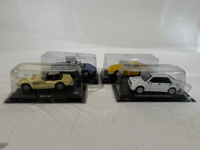 three toy cars are in a display case on a white surface