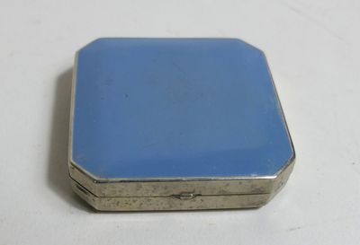 une image représentant une petite boîte bleue posée sur une table blanche
