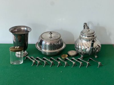 une table verte sur laquelle sont posés des objets en argent