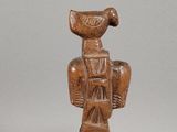 an image of a wooden statue of a woman with a basket on her head