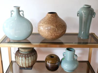 trois vases posés les uns à côté des autres sur une étagère en verre