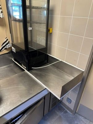 stainless steel counter top in a commercial kitchen with a glass door