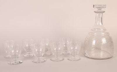 many glasses and a decanter sitting on a table