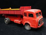 a red toy truck with a yellow top on a black background
