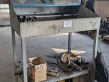 a metal work bench with a laptop on it in a warehouse