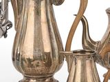 une cafetière en argent et une théière en argent posées sur une table