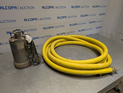 un tuyau jaune posé sur une table, à côté d'une pompe