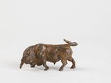 figurine of a bull on a white surface with a white background