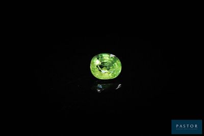 gros plan d'une pierre précieuse verte sur une surface noire