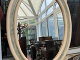 a mirror sitting on a window sill in front of a window