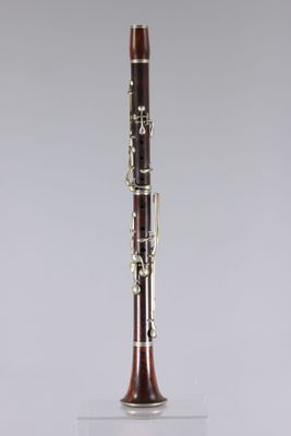 a close up of a clarinet on a stand with a grey background