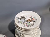 a stack of plates sitting on a table next to a cup and saucer