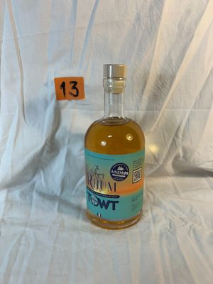 a bottle of liquor sitting on a bed with a price tag