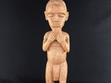 une statue sculptée représentant un homme avec un oiseau sur la tête