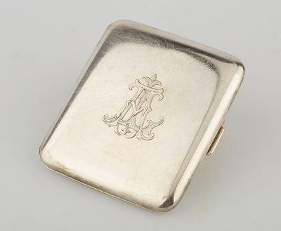 an antique silver cigarette case with a monogram on the front