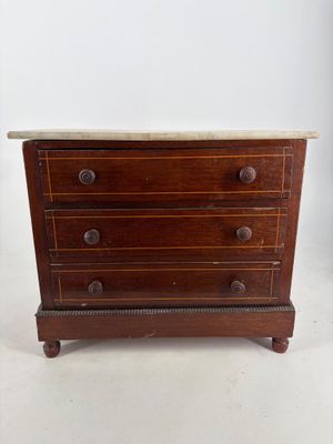 an old wooden chest of drawers with marble top