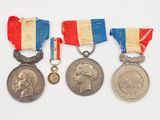 trois médailles et une médaille sur une surface blanche