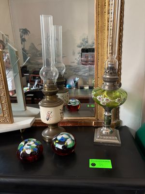 three glass vases on a black table with a mirror in the background