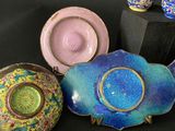 three teapots and two cups sitting on a table