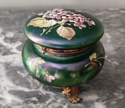 une boîte verte décorée de fleurs, posée sur une table