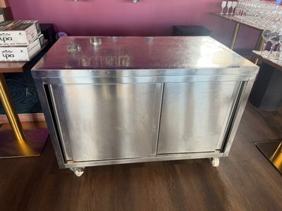une armoire en acier inoxydable munie d'un porte-verres à vin sur le dessus