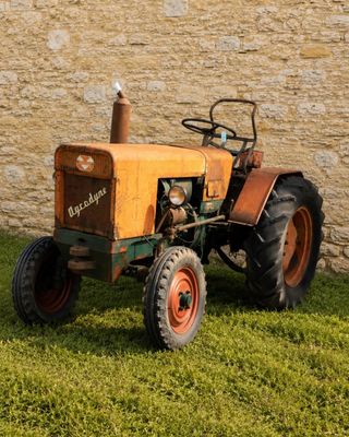 un petit tracteur qui est garé dans l'herbe