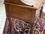a small wooden desk with a drawer on top of it
