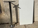 a white board leaning against a wall next to a metal pole