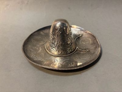 a silver plate with a silver bird on top of it