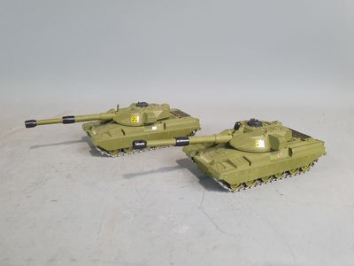 two toy tanks sitting side by side on a white surface