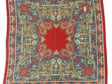 un tapis carré rouge, bleu et vert orné d'un motif floral