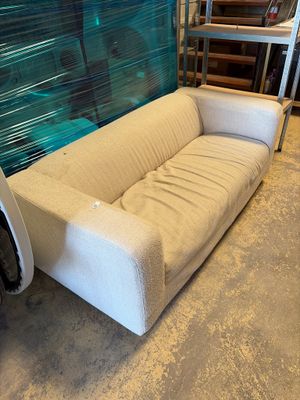 a white couch sitting in front of a large wall