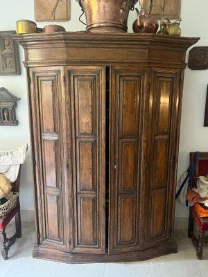 a large wooden cabinet with a pot on top of it