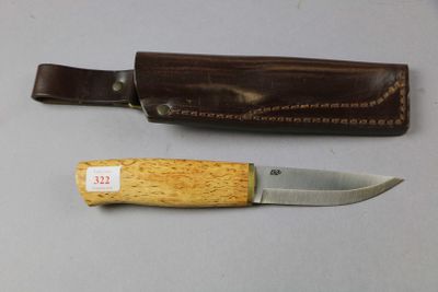a knife that is sitting next to a leather sheath