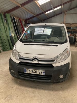 La camionnette blanche est garée dans le garage de l'immeuble.
