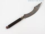 a knife that is laying on a white surface
