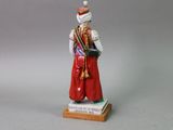 figurine of a woman in a red dress with a hat and scarf