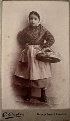 an old photo of a young girl holding a basket