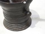 a metal cup with a handle on a white surface