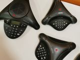 three black telephones sitting on top of a table next to each other