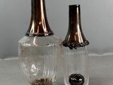 two glass vases sitting next to each other on a table