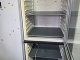 an empty refrigerator in a small room with no doors