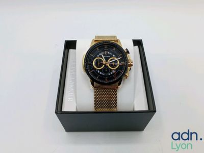 La montre se trouve dans sa boîte, posée sur la table, prête à être utilisée.